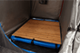 An internal look at a shower tent with a wooden shower base inside