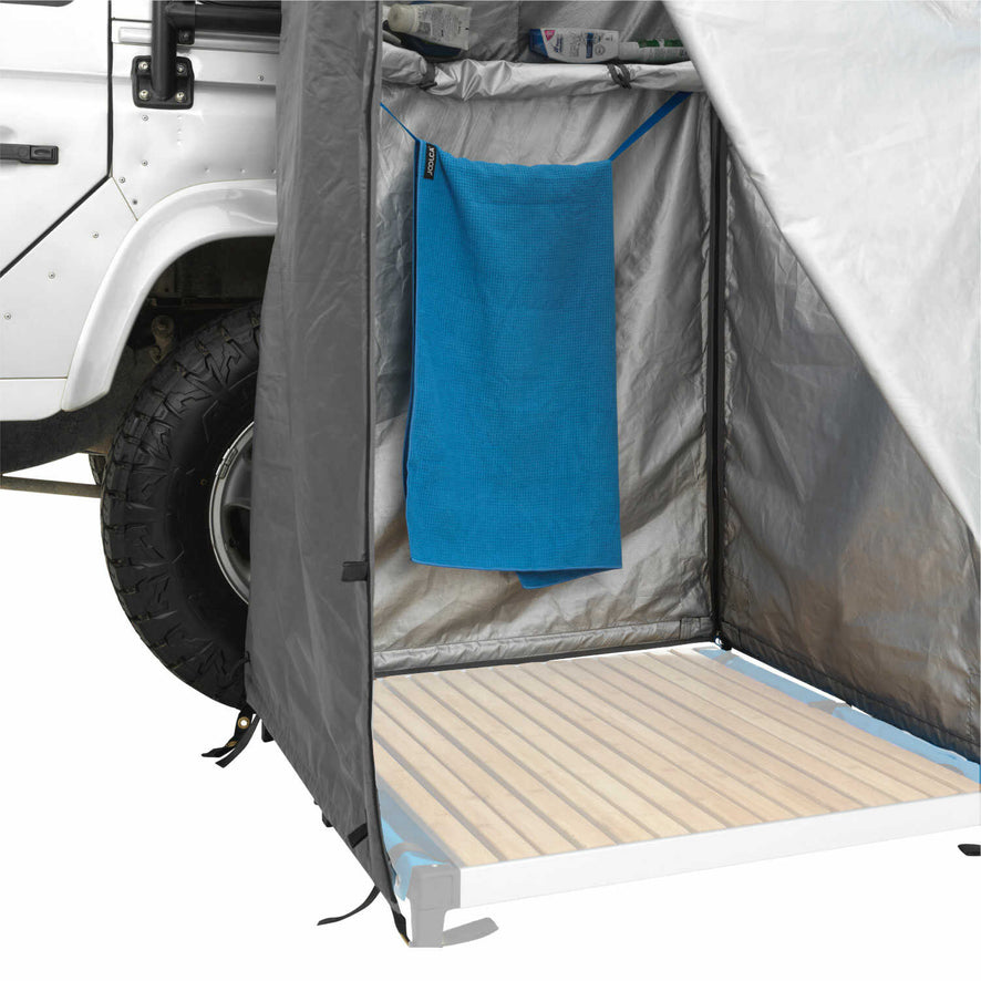 An open mounted shower tent with a hanging towel and an opac shower base