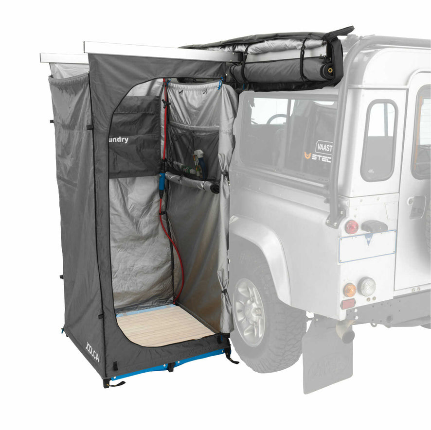 A side view with one side of a double mounted tent rolled up and the other side with an internal shower