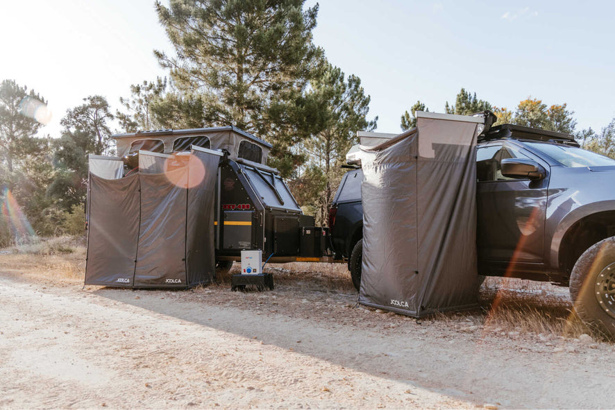 A mounted single tent attached to a 4WD and an mounted double attached to a caravan on a dirt road