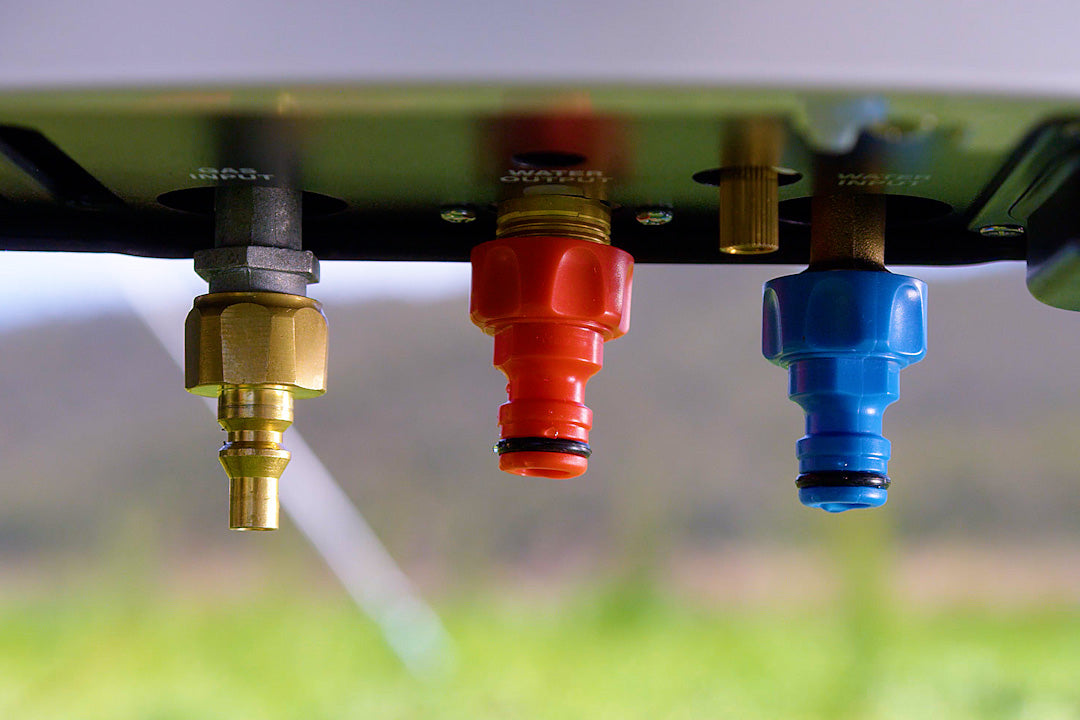 Close-up of the brass gas fitting and red and blue quick-connect water fittings under the HOTTAP V2