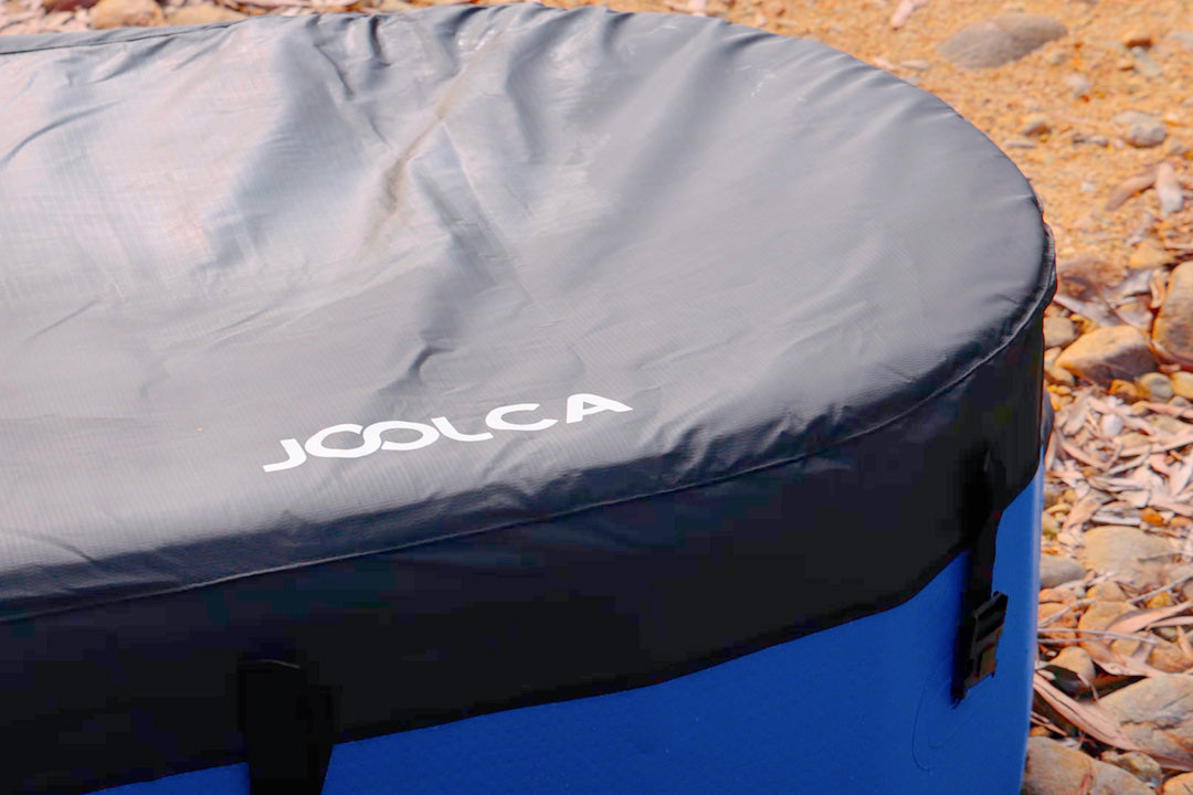Close-up of the black Joolca insulated cover fitted over a blue HOTTUB