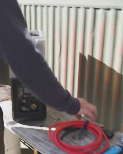 Person packing the coiled hose into the HOTTAP Go's built-in storage.