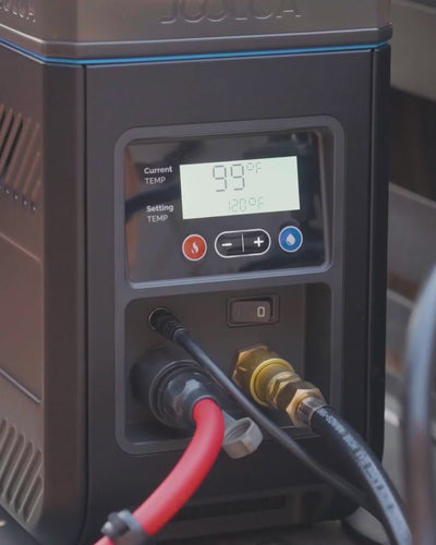 Finger adjusting temperature controls on the HOTTAP Go water heater display.