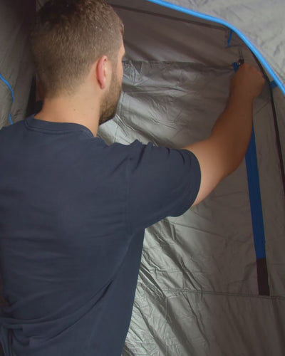 Man opening the flyscreen window on a Joolca Ensuite tent, then standing inside behind the mesh