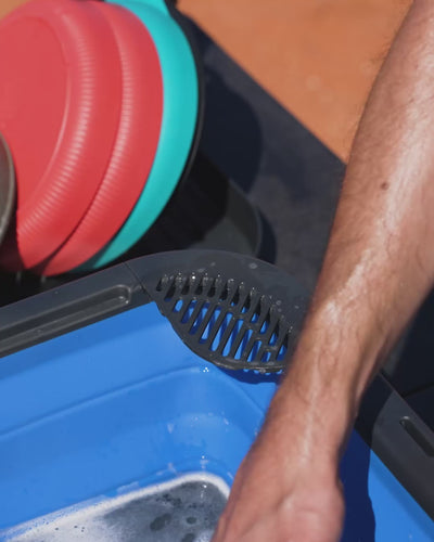 Corner strainer in the Flexi Sink beside a stack of plates