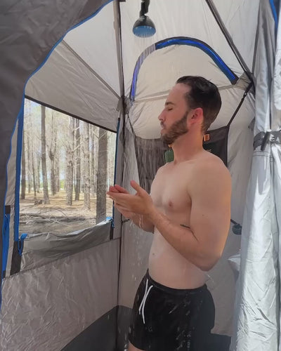 Man standing inside the Joolca Ensuite Double tent, seen through the striped privacy door